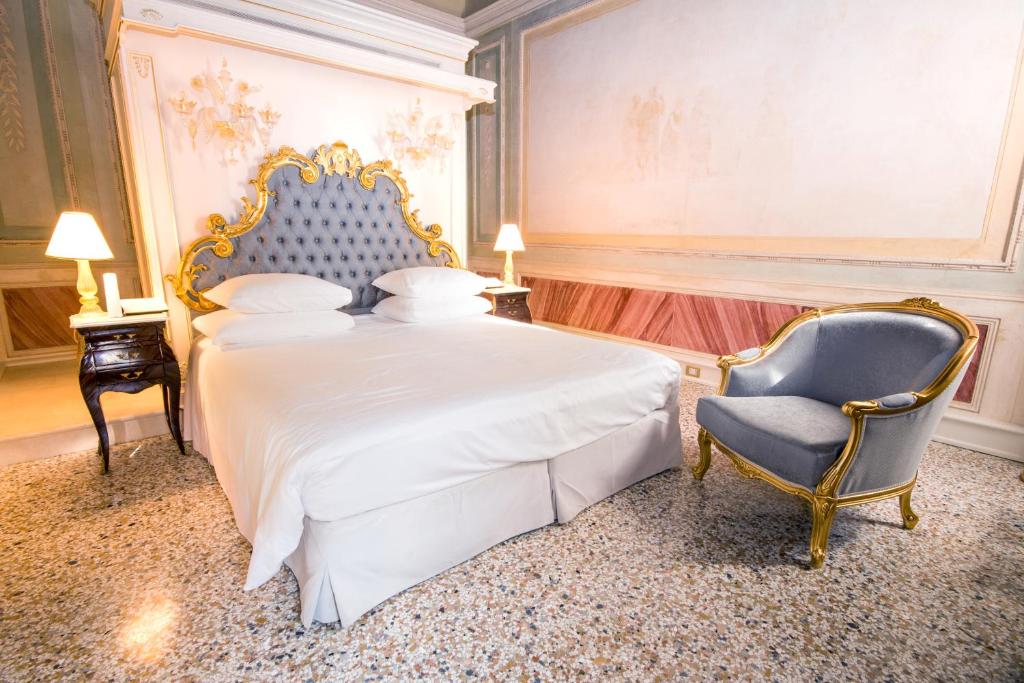 a bedroom with a king sized bed and a chair at Ca' Bonfadini Historic Experience in Venice