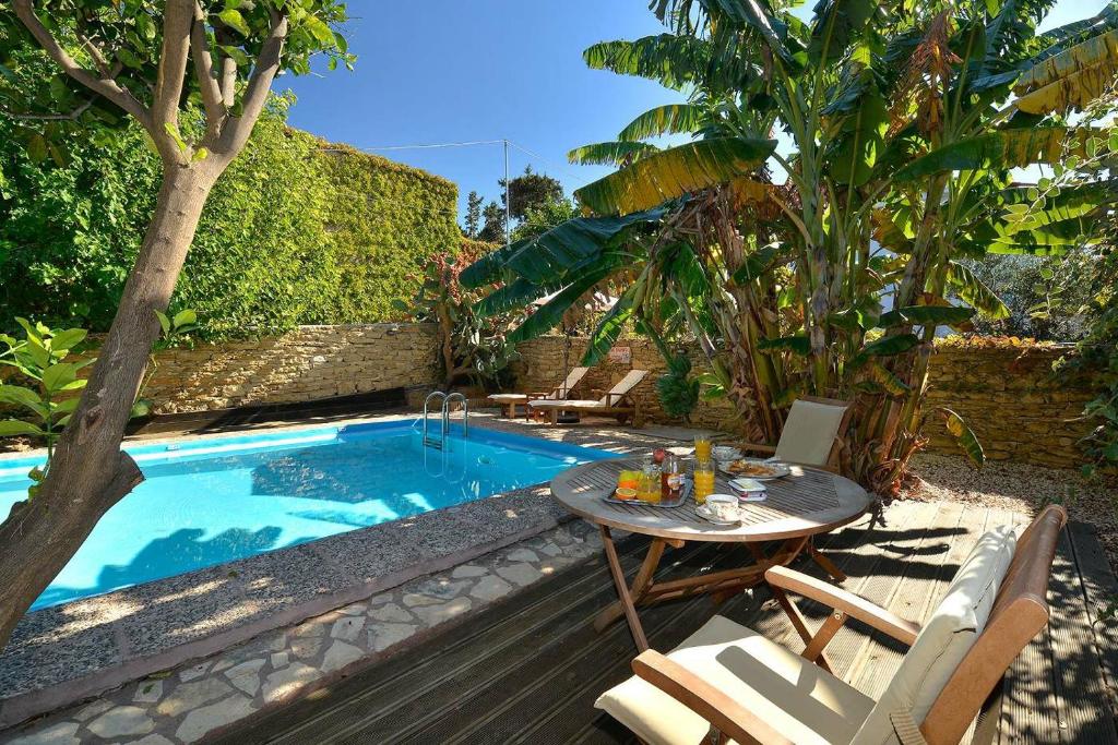 a table and chairs next to a swimming pool at Villa Kamares Private pool in Kondomari