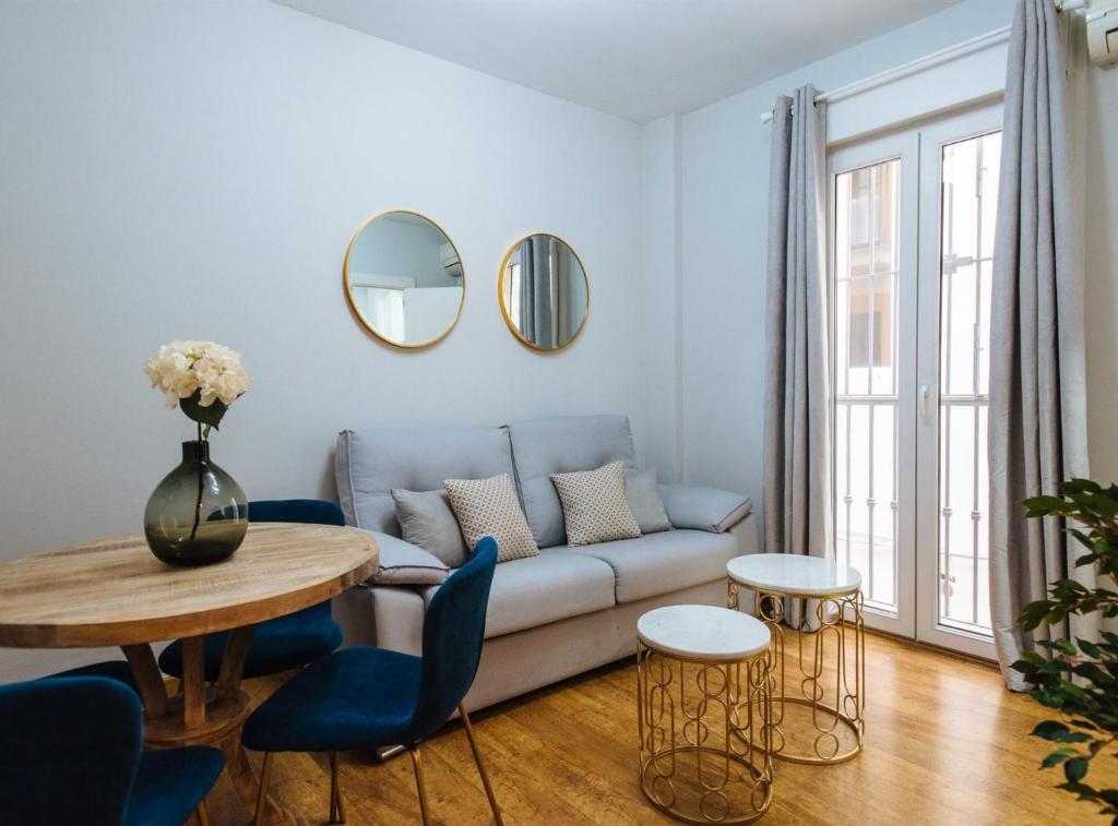 een woonkamer met een bank en een tafel bij Feijóo Suite Apartment in Sevilla