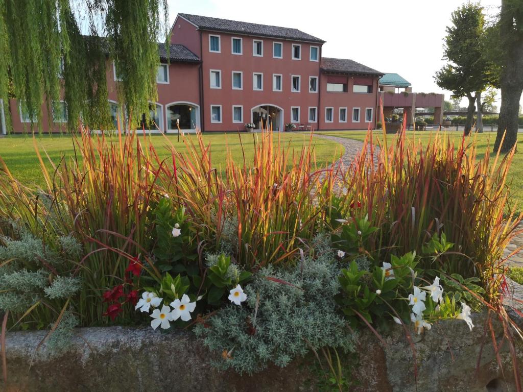 a garden with flowers in front of a building at Tenuta Santomè in Biancade