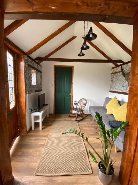 Blythburgh的住宿－Cute mini-studio in Blythburgh，客厅设有床和绿门