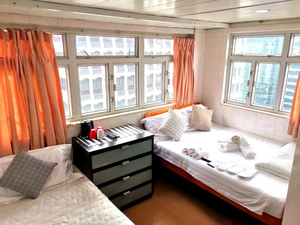 two beds in a room with windows at 志城住房 in Hong Kong