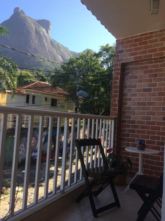 una silla en un balcón con una mesa y una montaña en Casa Zona Sul en Río de Janeiro