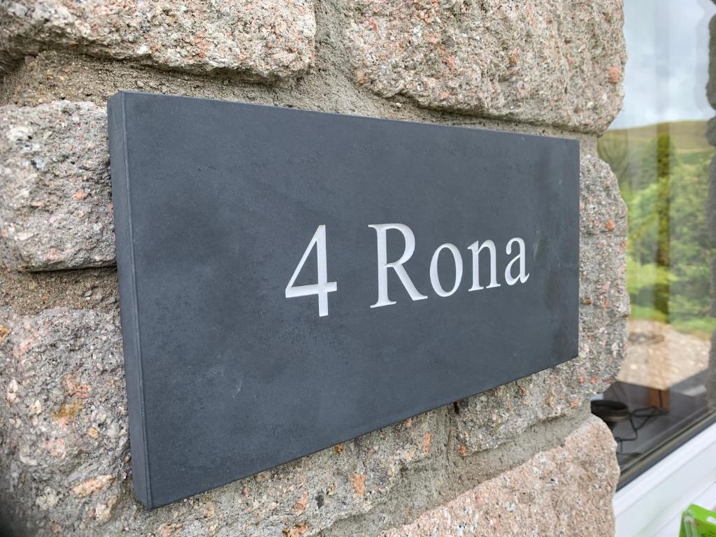 a sign that reads roma on a stone wall at Rona@Knock View Apartments, Sleat, Isle of Skye in Teangue