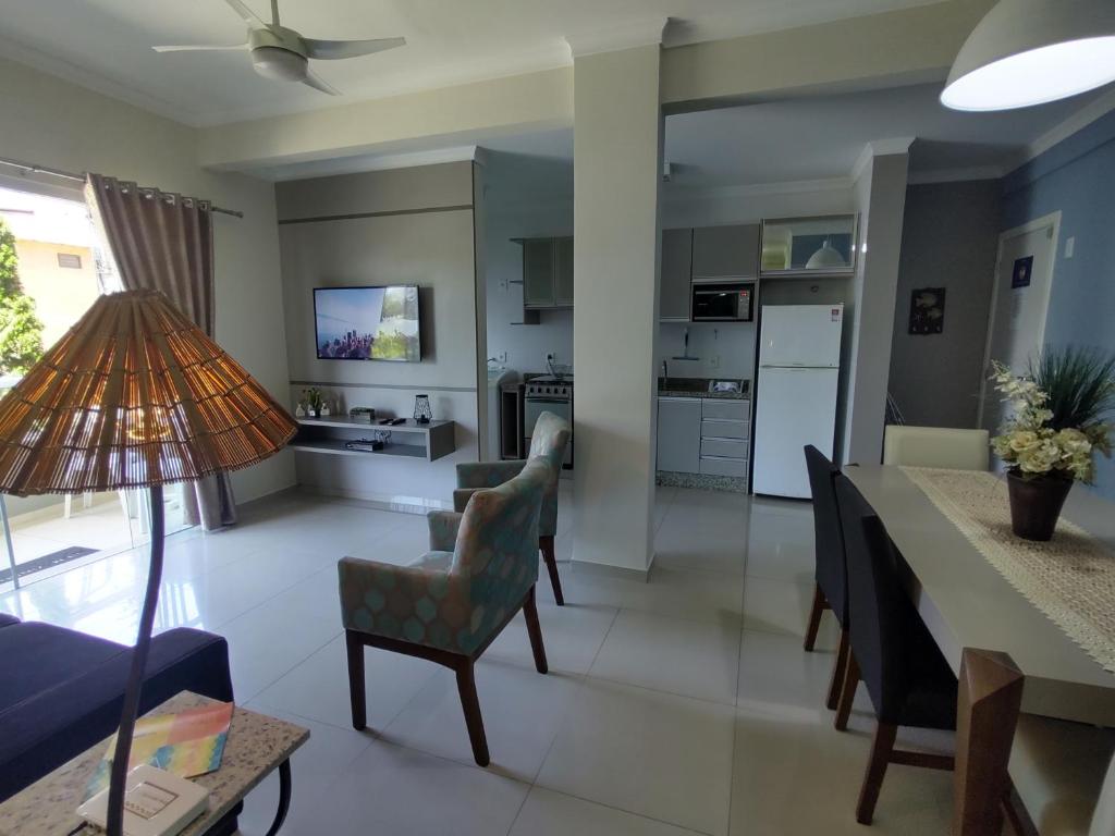 a kitchen and living room with a table and chairs at Bombinhas Centro, apartamento 02 dorm, ótima localização in Bombinhas