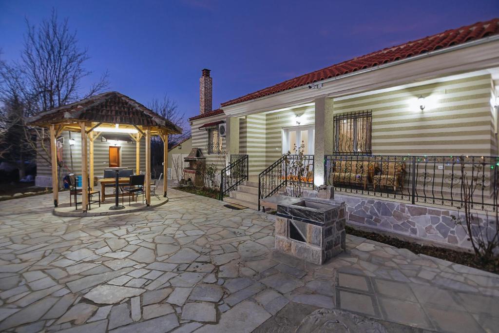 un patio con cenador junto a una casa en Vila 1 en Korçë