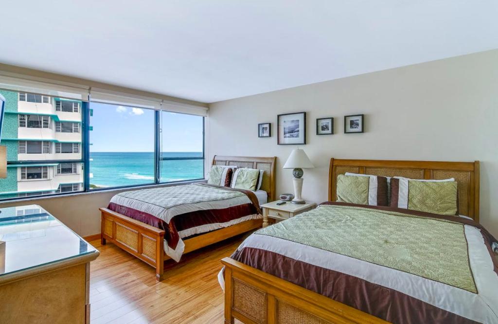 2 camas en una habitación con vistas al océano en Waterfront condo on beach with pool, tiki bar & restaurant on-site, en Miami Beach