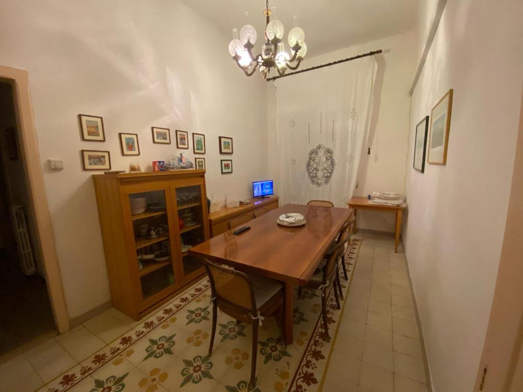 a dining room with a wooden table and a chandelier at Casa Diroma in Ginosa Marina