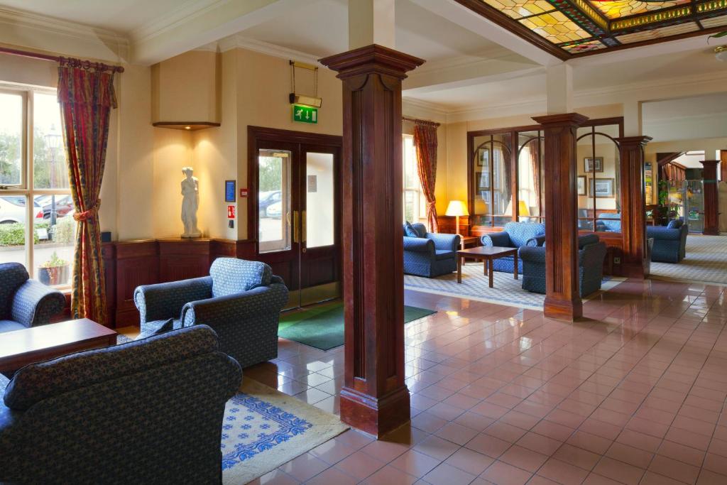 a lobby with couches and chairs in a building at Holiday Inn Ipswich Orwell, an IHG Hotel in Ipswich