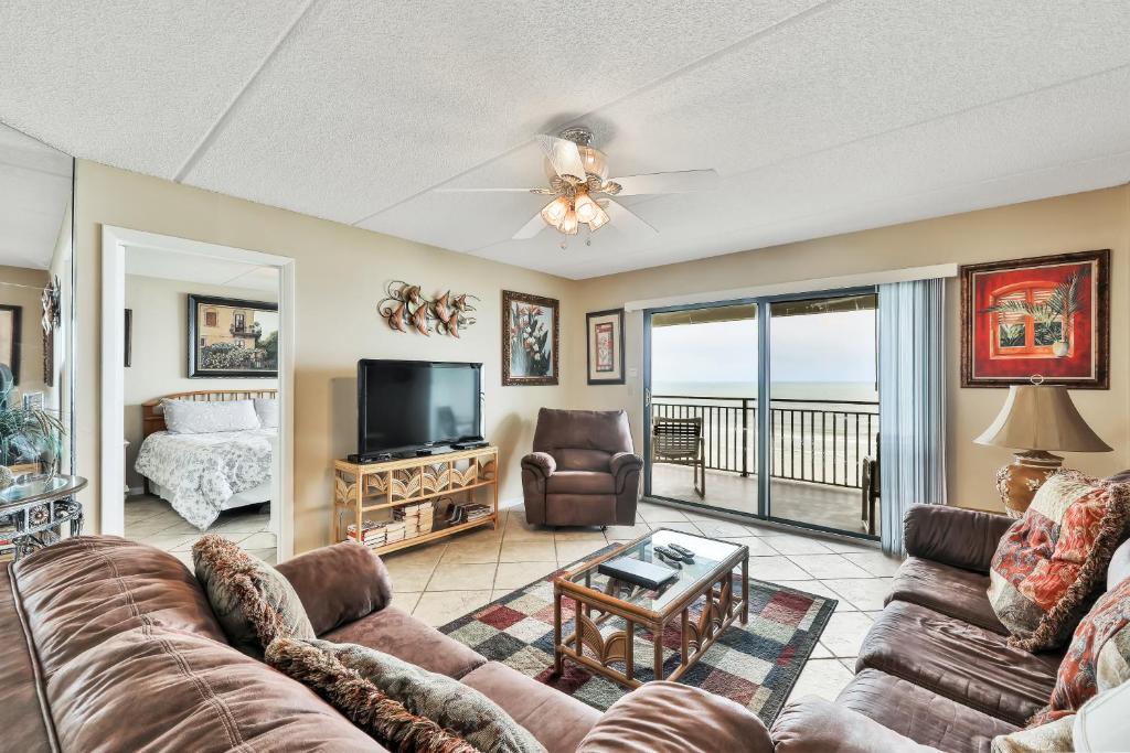 ein Wohnzimmer mit einem Sofa und einem TV in der Unterkunft Oceanfront Windjammer Getaway in St. Augustine