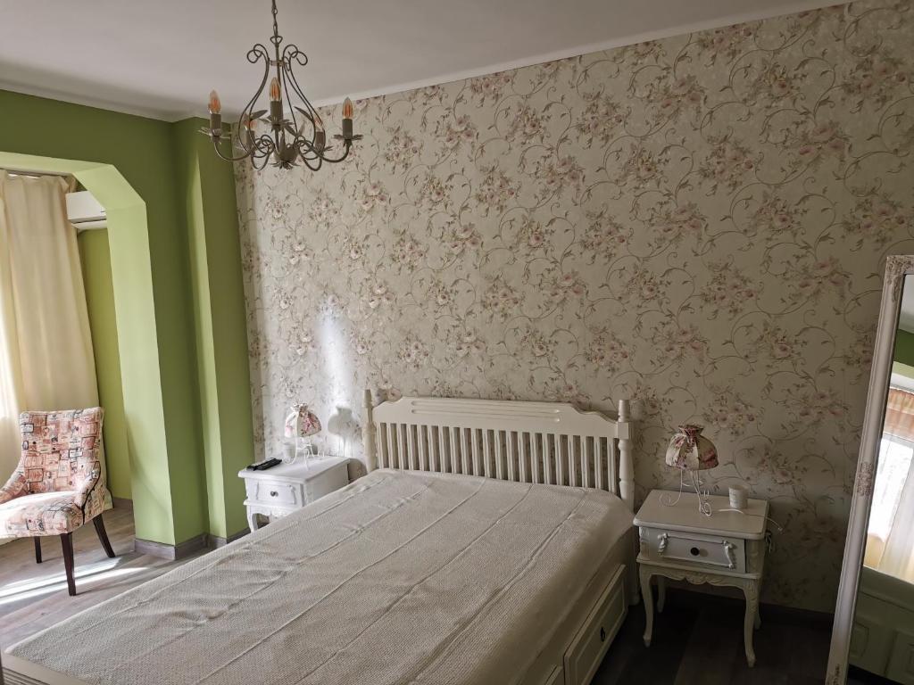 a bedroom with a bed and green walls and a chandelier at Chic Apartment in Brăila