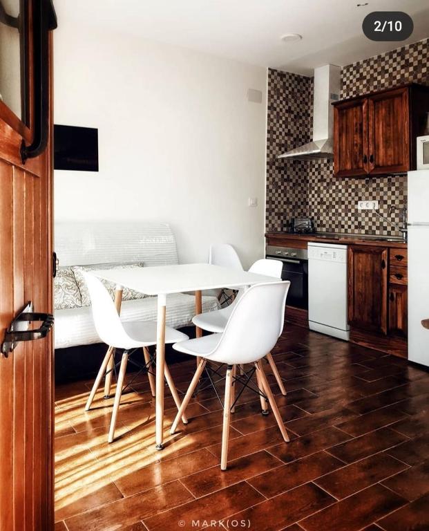 a kitchen with a white table and white chairs at Orion in Torrejón el Rubio