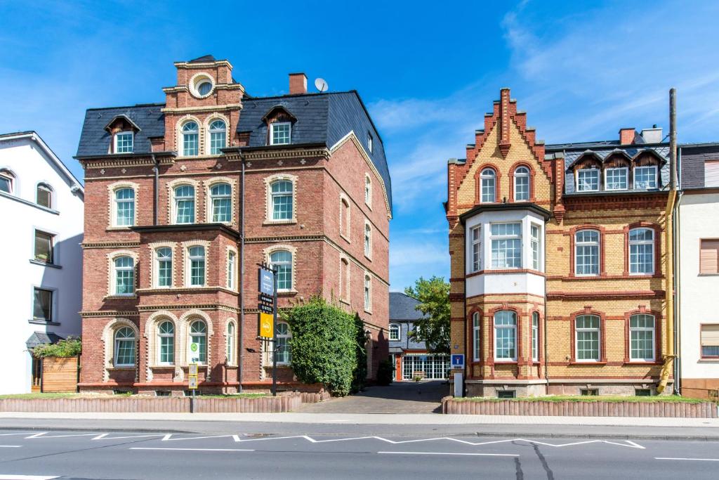 two old brick buildings next to each other on a street at Hotel Stein - Schiller's Manufaktur in Koblenz