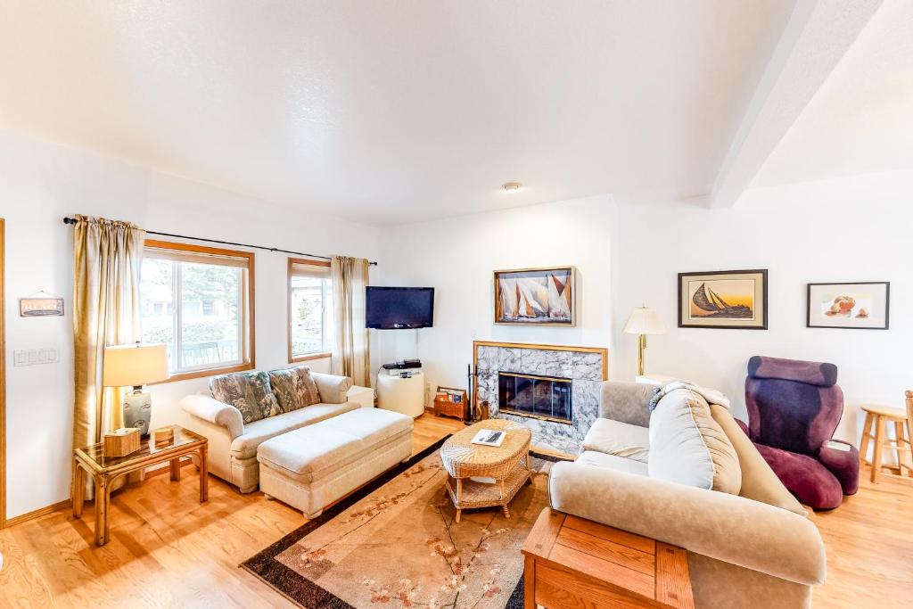a living room with two couches and a fireplace at Seaside Serenade in Seaside