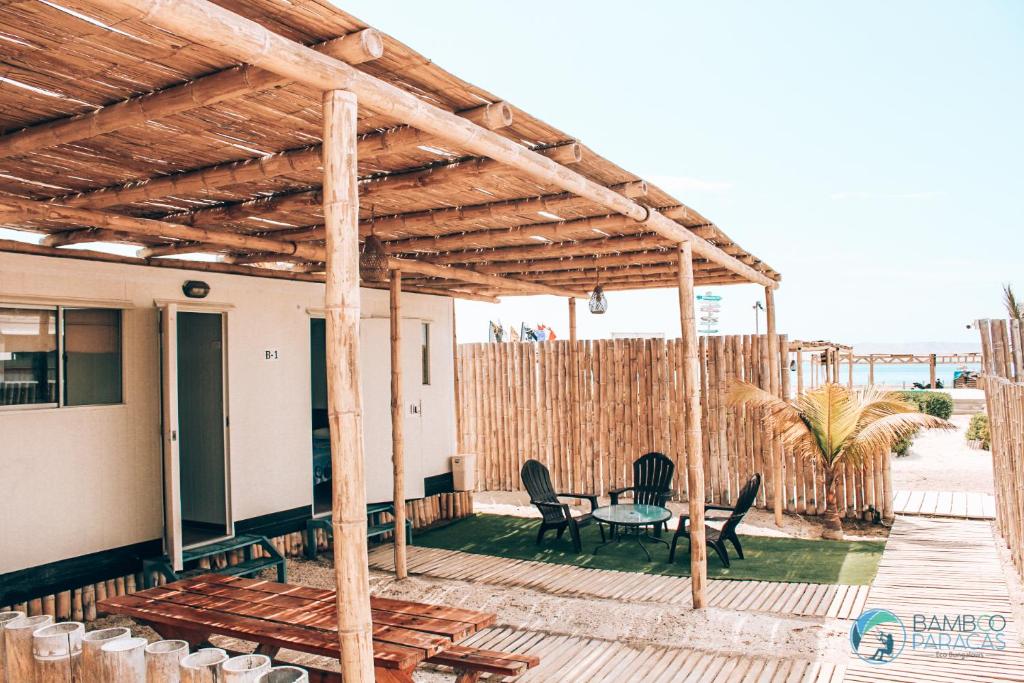 a patio with chairs and a table on a deck at Bamboo Paracas Resort in Paracas