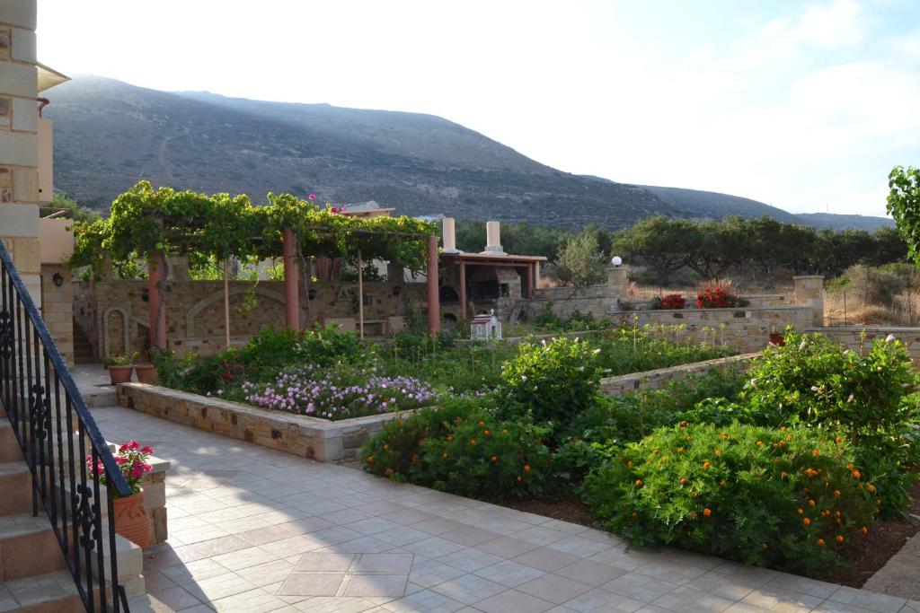 a garden with flowers and a mountain in the background at Romantica Apartments in Falasarna