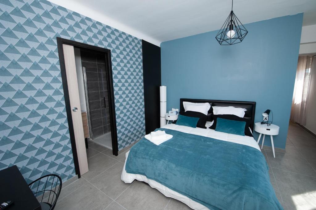 Dormitorio azul con cama y pared azul en Explore the World 1 en Perpiñán