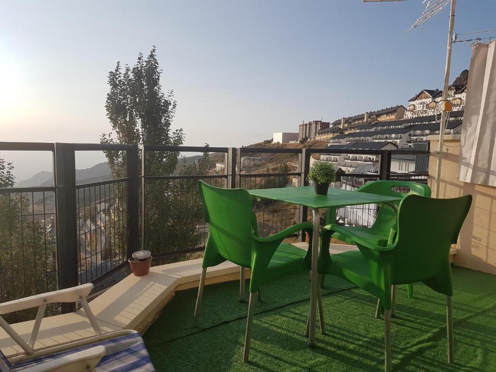 d'une table et de chaises vertes sur un balcon dans l'établissement los valles con vistas, à Sierra Nevada