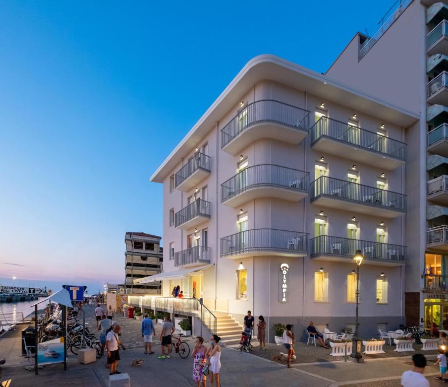 a building with people standing outside of it at Hotel Olympia in Gabicce Mare