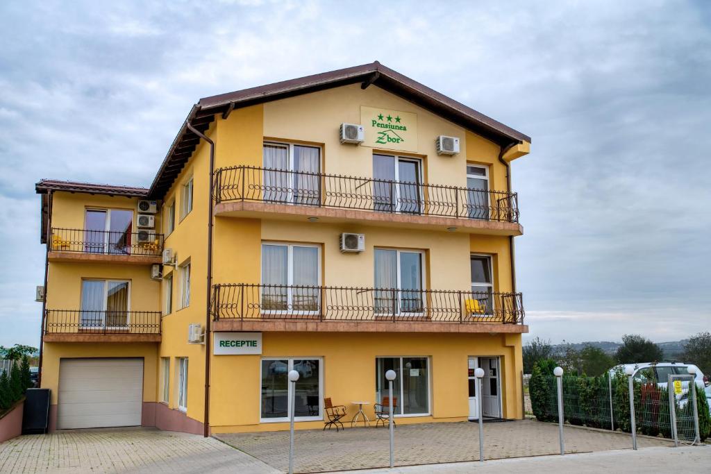 un edificio amarillo con 2 balcones en Pensiunea Zbor en Cluj-Napoca