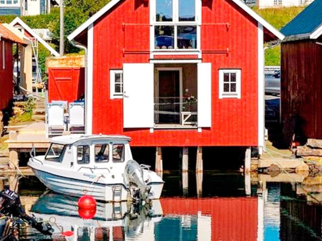 un barco está atracado frente a una casa roja en Holiday home bud II, en Bud