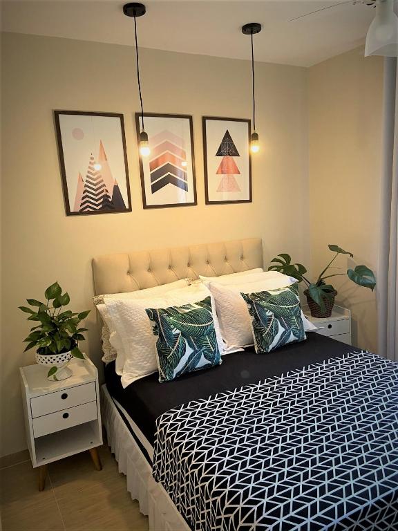 a bed in a bedroom with pictures on the wall at Vila Noel Premium in Penedo
