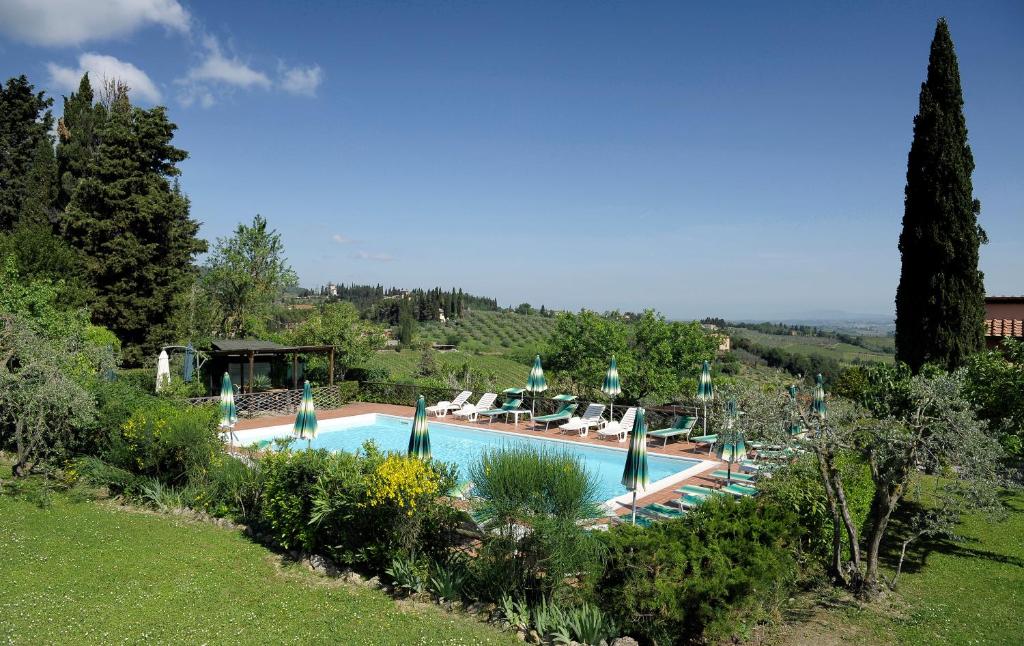 a beach with a pool and trees at Hotel Villa Belvedere in San Gimignano