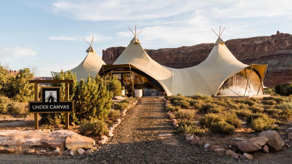 Un chapiteau dans le désert avec des montagnes en arrière-plan dans l'établissement Under Canvas Moab, à Moab