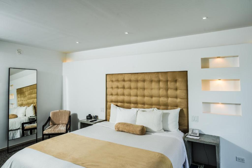 a hotel room with a large bed and a mirror at Riande Aeropuerto Hotel Casino in Tocumen