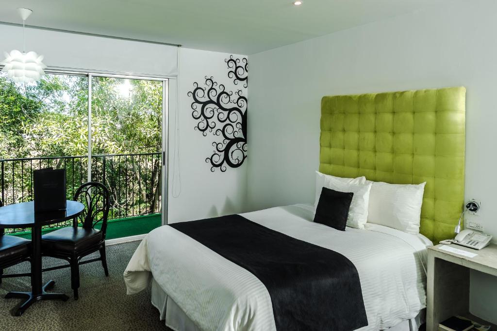 a bedroom with a bed and a table and a window at Riande Aeropuerto Hotel Casino in Tocumen