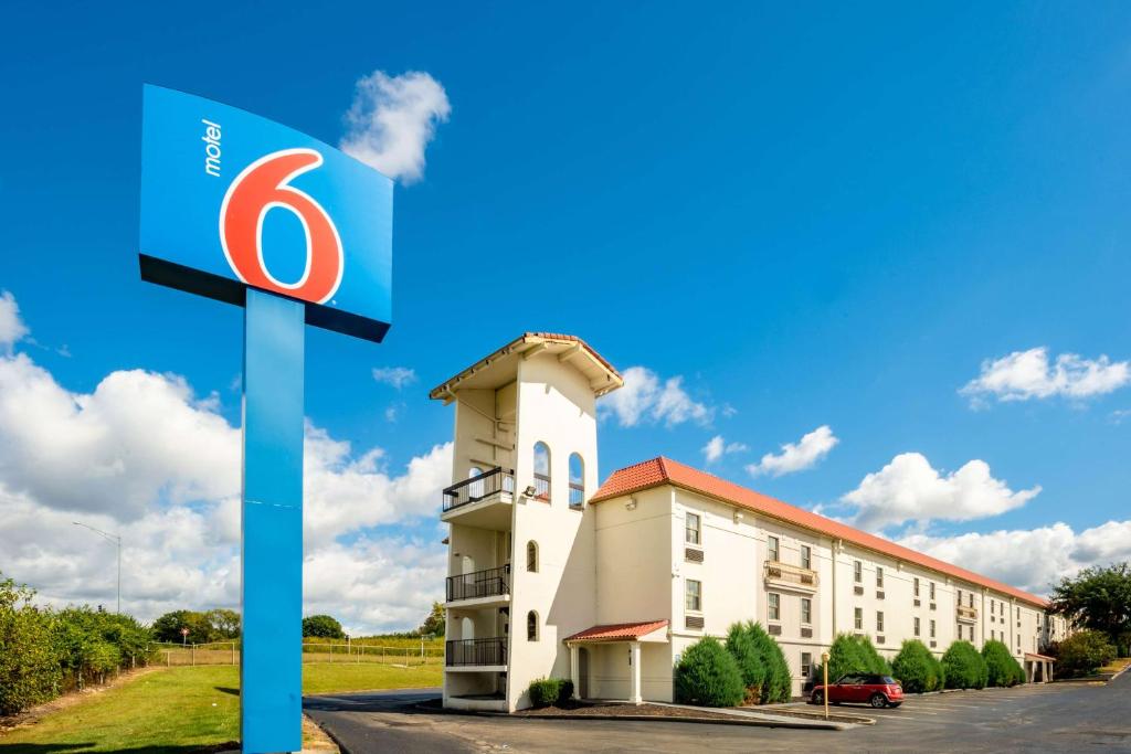 una gasolinera con un cartel frente a un edificio en Motel 6-Hazelwood, MO en Hazelwood