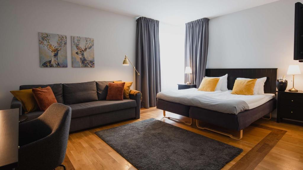a living room with a bed and a couch at Hotell Erikslund in Ängelholm
