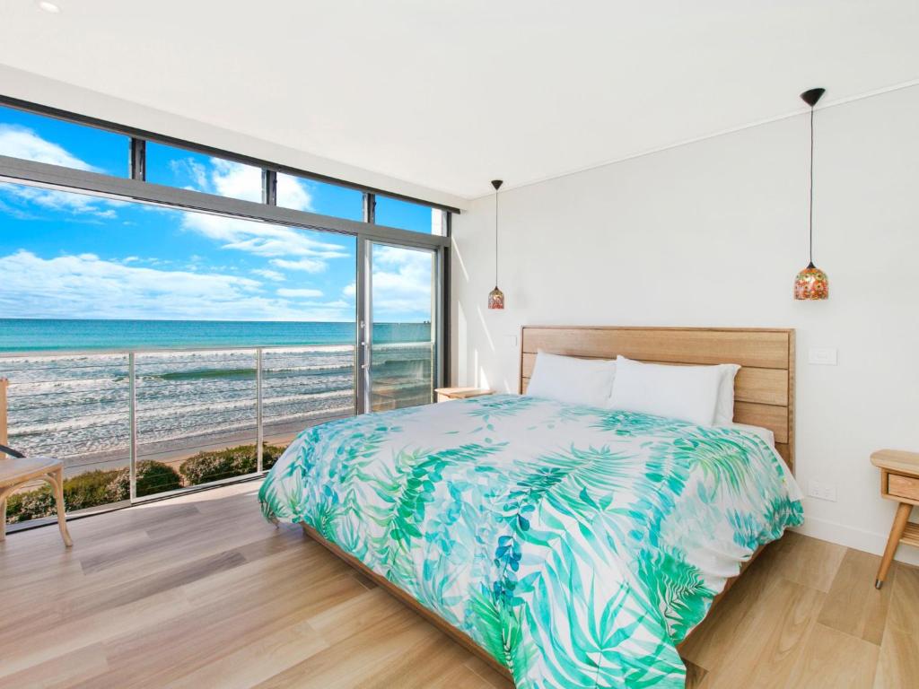 a bedroom with a bed and a view of the beach at Oceanview in Port Fairy