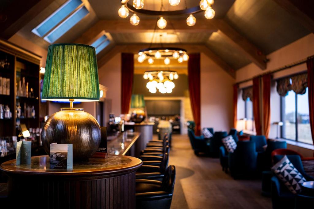 un restaurant avec un bar doté de chaises et d'une lampe dans l'établissement The Salthouse Hotel, à Ballycastle
