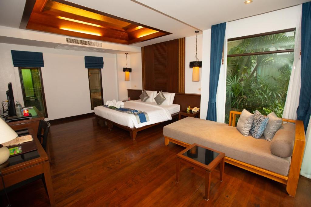 a hotel room with two beds and a couch at Railay Village Resort in Railay Beach