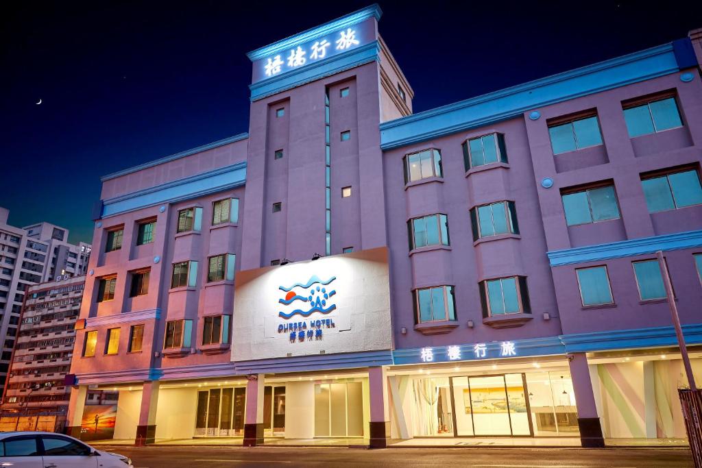 a building with a sign on top of it at Oursea Hotel in Wuqi