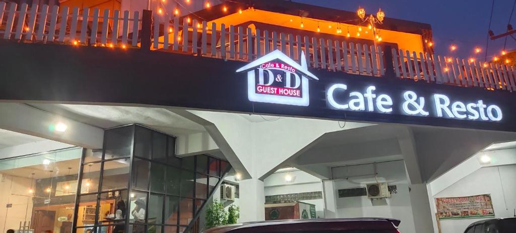 een bord voor een café en restaurant bovenop een gebouw bij D&D Guest House & Cafe Syariah in Medan