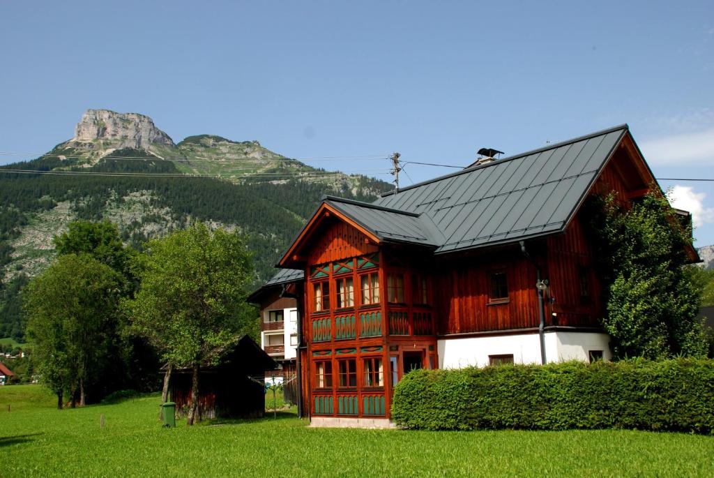 ein Holzhaus mit einem Berg im Hintergrund in der Unterkunft Haus Moser in Altaussee