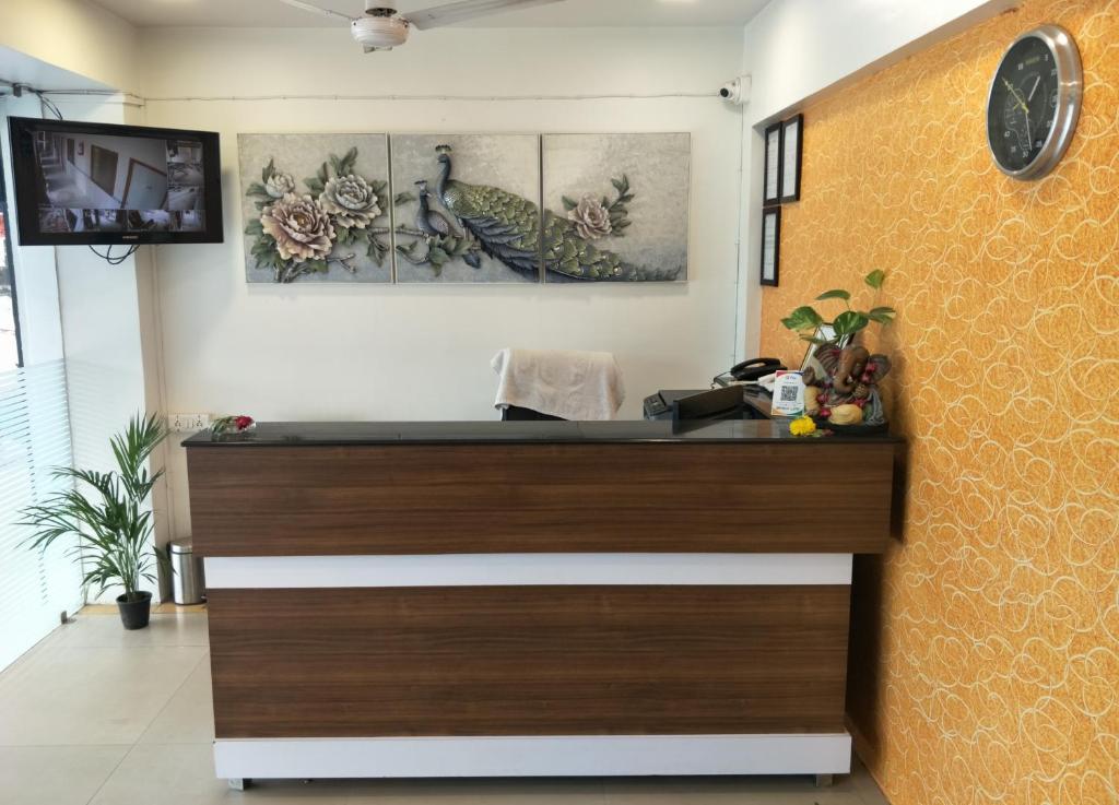 a reception desk in a room with a clock on the wall at HOTEL RUNWAY INN in Ahmedabad