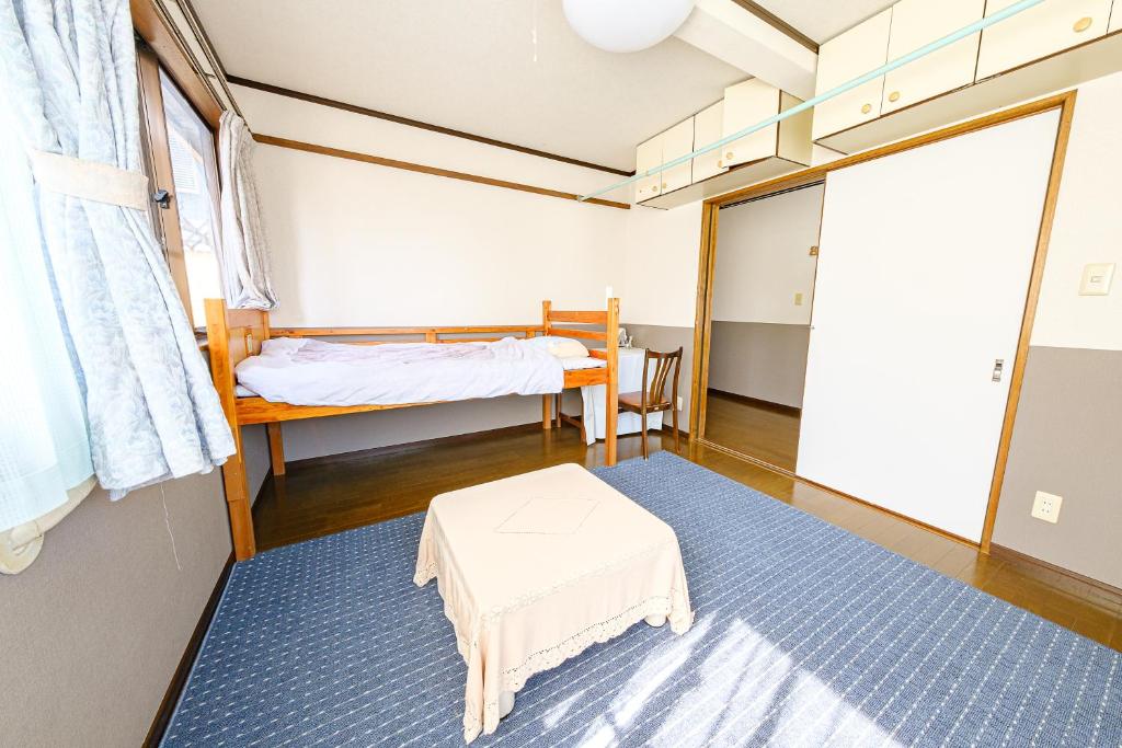 長崎市にある渡邊民泊のベッドとテーブル付きの小さな部屋