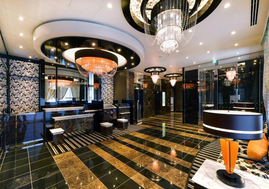 a lobby with a bar and chandeliers at APA Hotel Nagoya Ekimae Minami in Nagoya