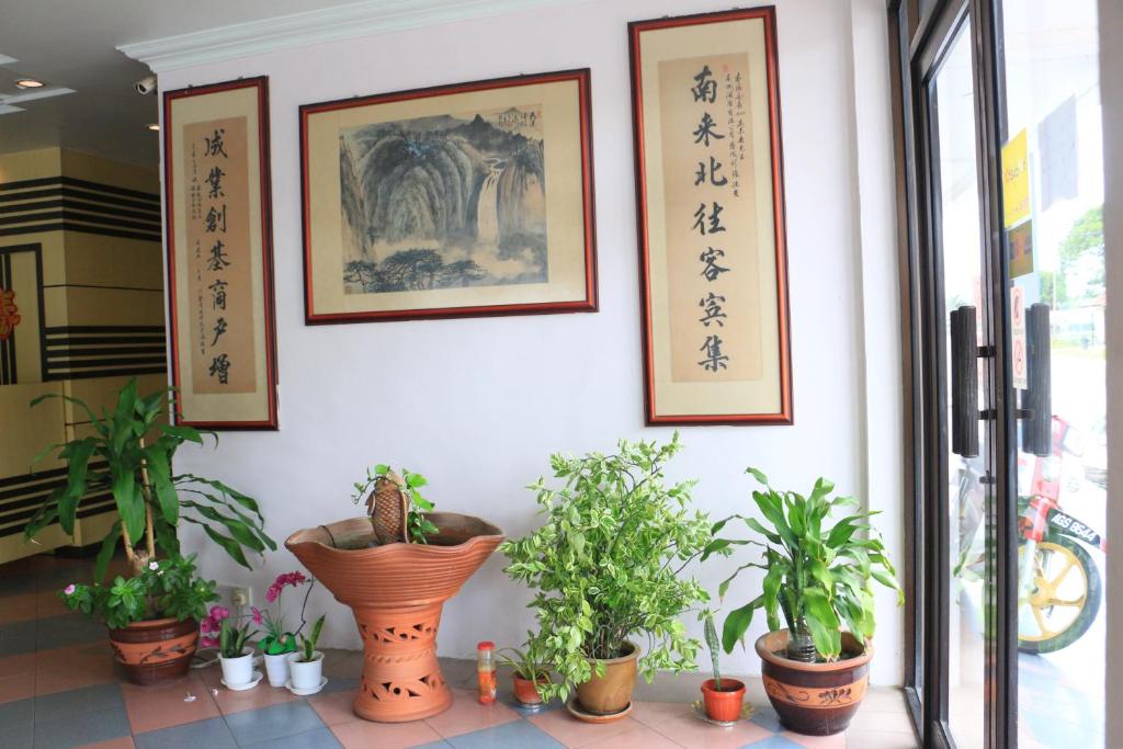 una habitación con plantas y cuadros en la pared en Hotel Lam Seng en Pantai Remis