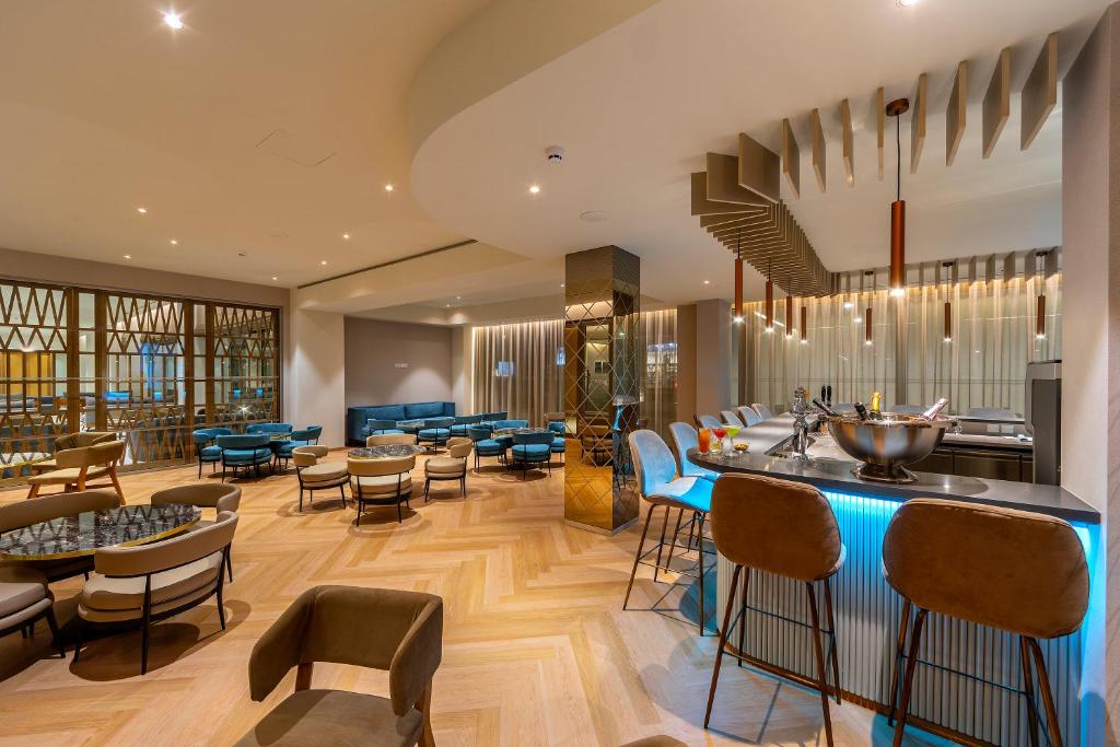 a bar in a restaurant with chairs and tables at Faros Hotel Ayia Napa in Ayia Napa