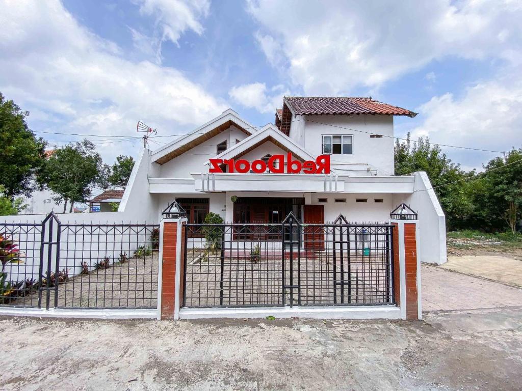 ein Gebäude mit einem Tor vor einem Restaurant in der Unterkunft RedDoorz near Eco Green Park Batu in Batu