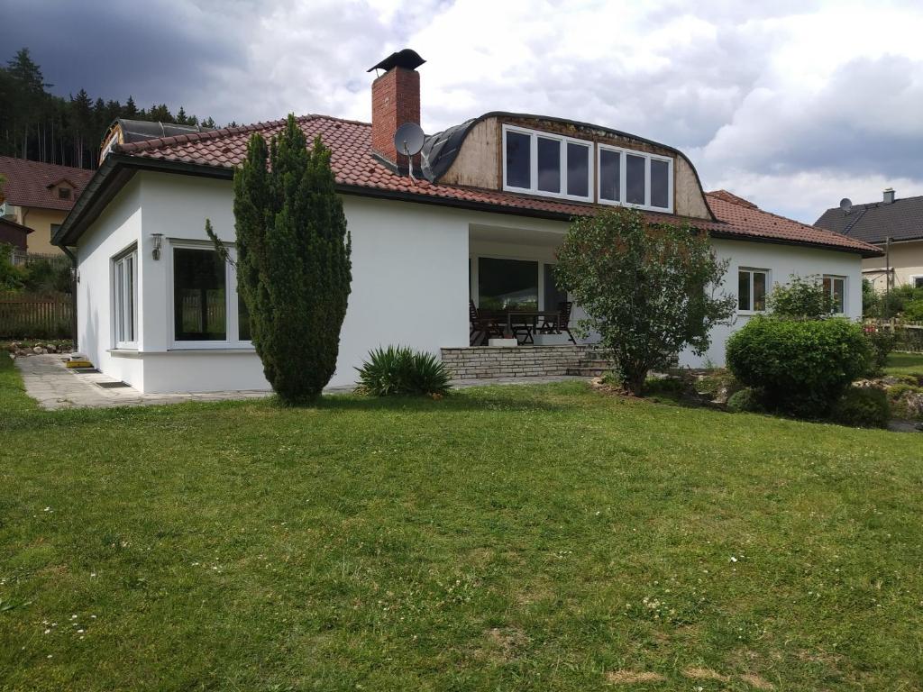 a white house with a grass yard at Ferienwohnung Betz in Riedenburg