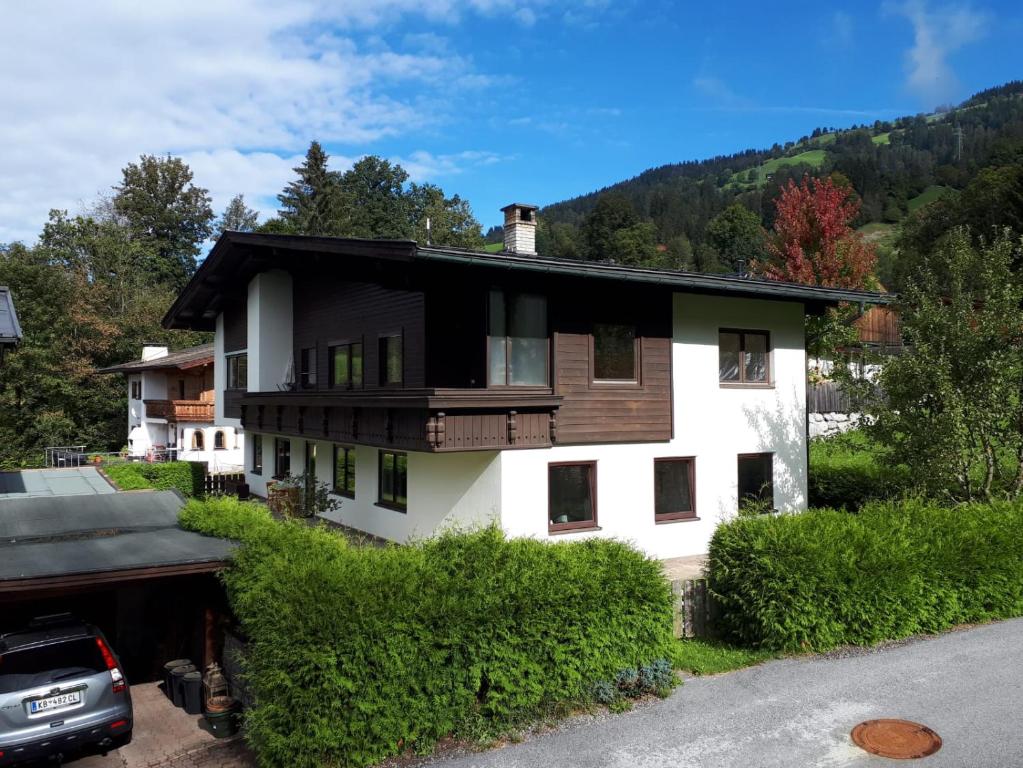 ein weißes Haus mit schwarzem Dach in der Unterkunft Haus Yvonne in Hopfgarten im Brixental