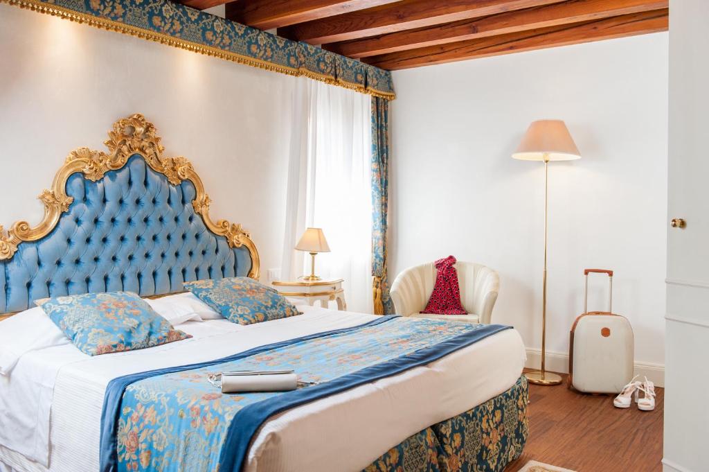 a bedroom with a large bed with a blue headboard at Master Venice Apartments in Venice