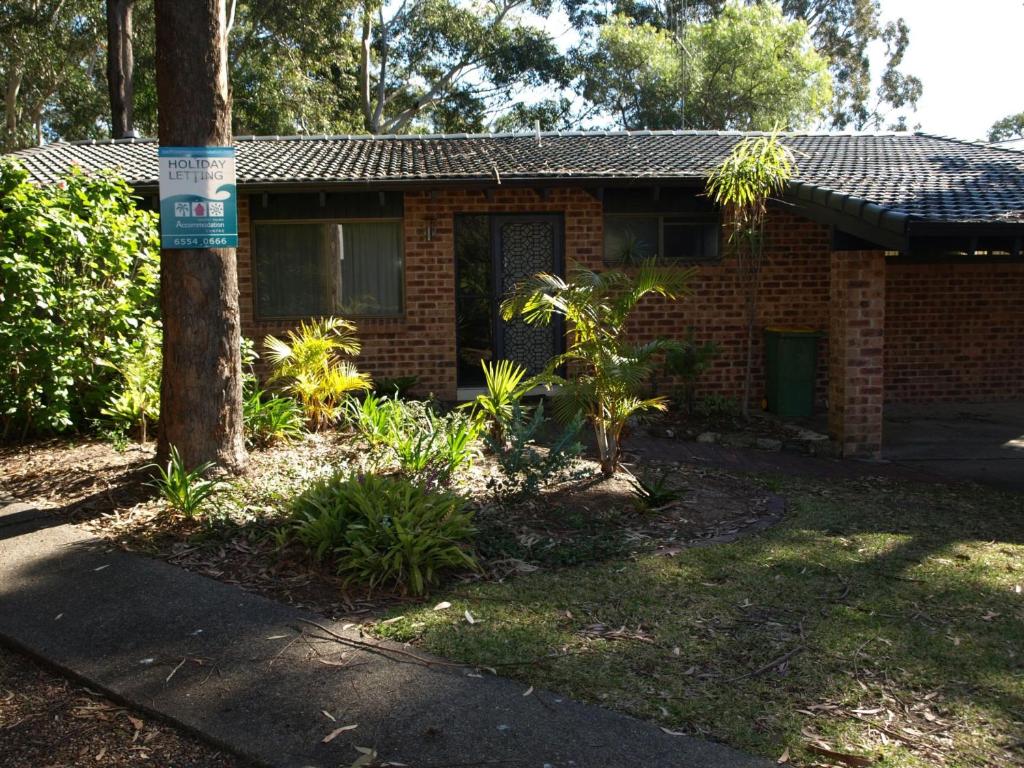 a brick house with a tree in front of it at SPLASH in Elizabeth Beach