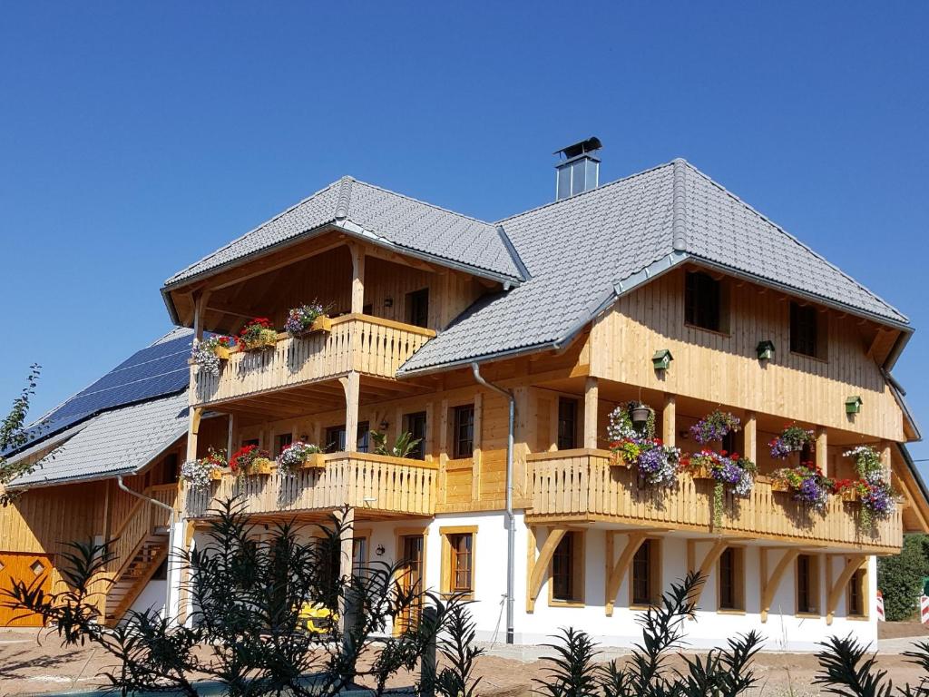 una grande casa in legno con fiori sui balconi di Fischerhof a Höchenschwand