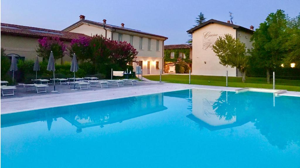 a swimming pool in front of a house at Agriturismo Feliciana in Pozzolengo
